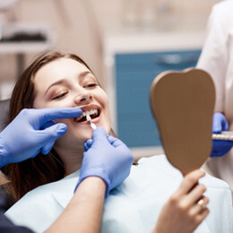 a dentist using a shade guide for a patients cosmetic dental work