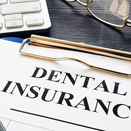 Dental insurance form on a clip board with a fountain pen