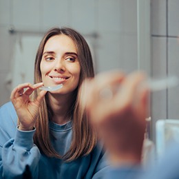 Invisalign patient in Nepean smiling in the mirror